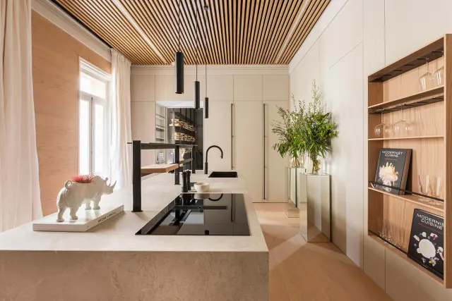 Kitchen island under a natural wood-look slat ceiling
