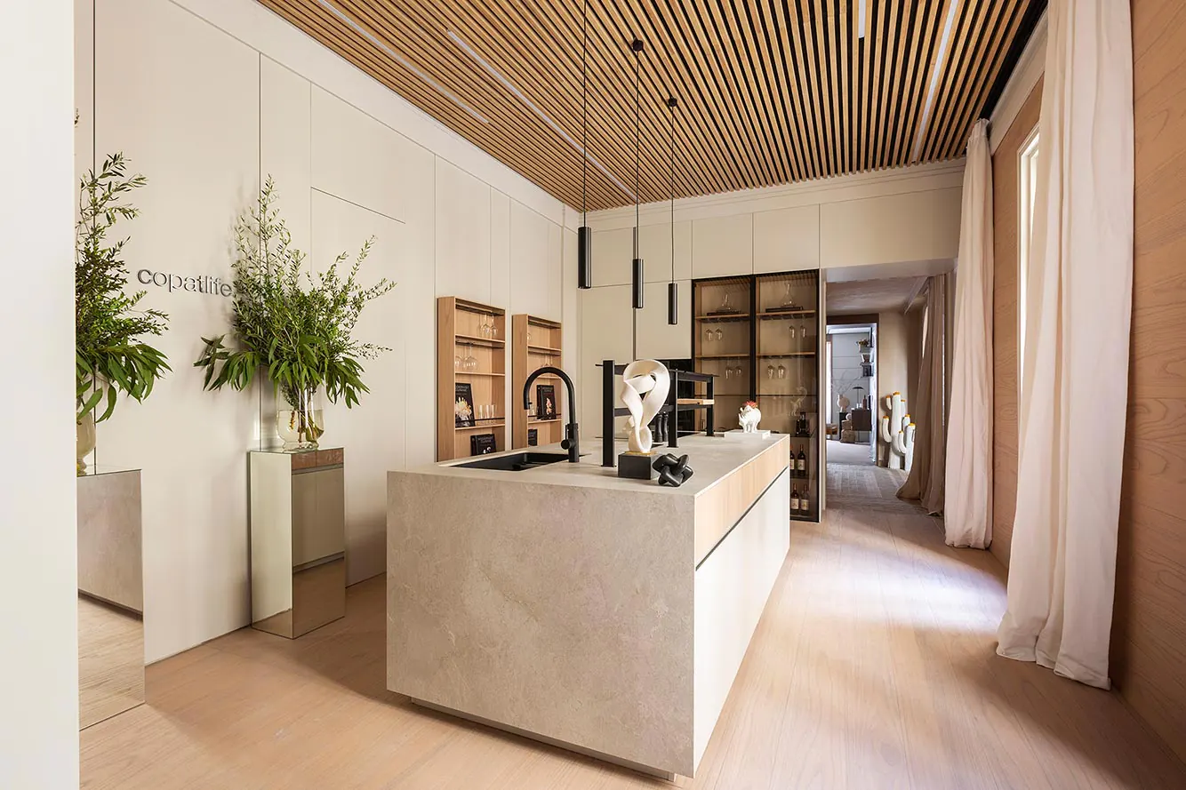 Kitchen showroom with a natural wood-look slat ceiling above the stone island