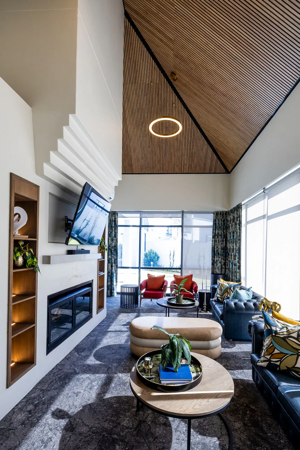 Living room with a vaulted natural wood-look slat ceiling above the fireplace and television