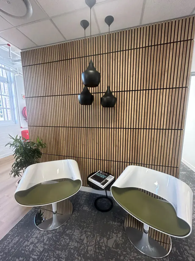 Lounge seating against a natural wood-look slat wall