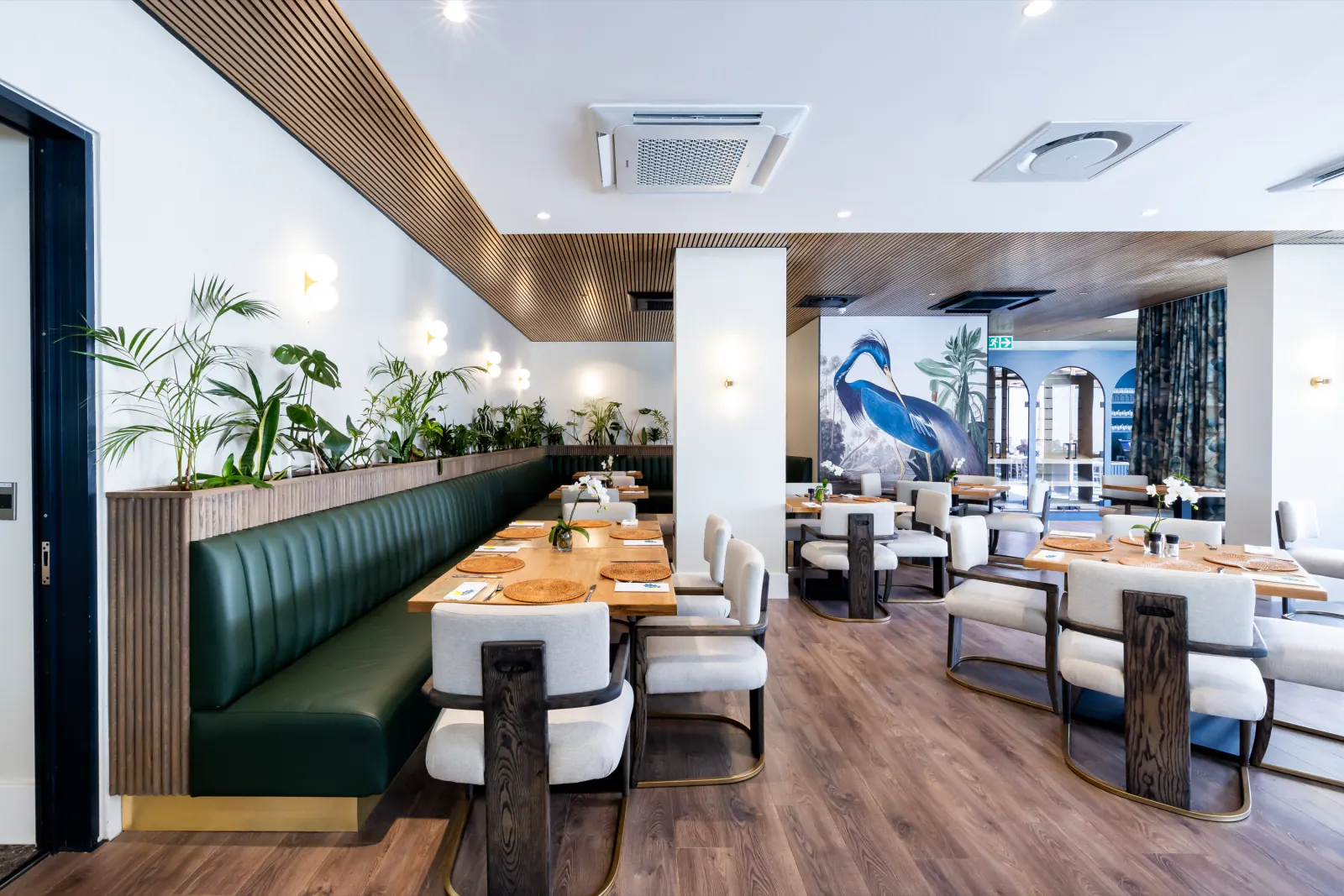 Restaurant dining room with a natural wood-look slat ceiling bulkhead running above the banquette