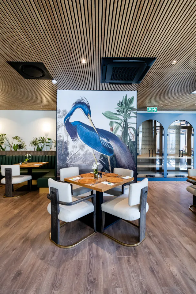 Restaurant with a full natural wood-look slat ceiling above the tables